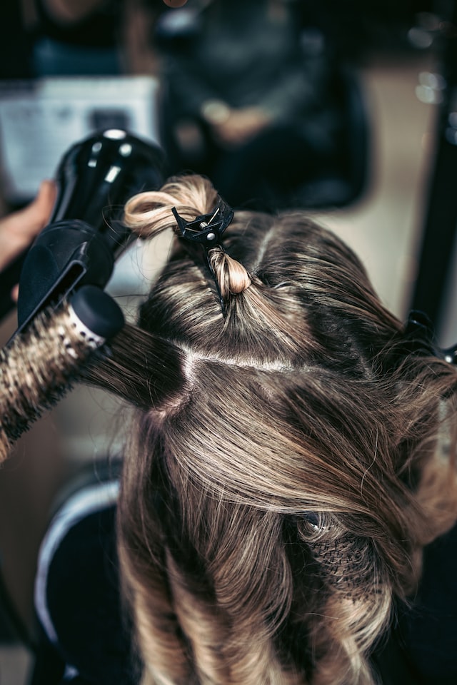 person using round hair brush