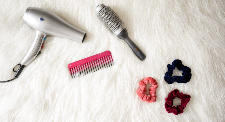 round hair brush with hair dryer on the bed