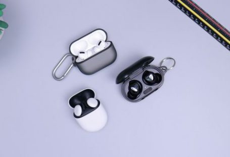 Wireless Earbuds - black and white headphones on white table