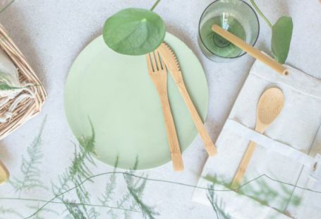 Eco-friendly - a green plate with wooden utensils on it