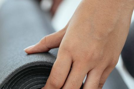 Fitness Equipment Deals - Crop female holding rolled mat on floor