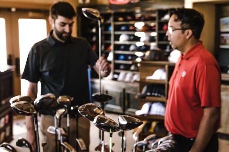 Golf Clubs - Man Standing Beside Man Holding Gray Golf Club