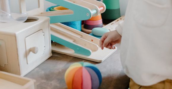 Sustainable Toys - A Child Looking at His Toys on the Table