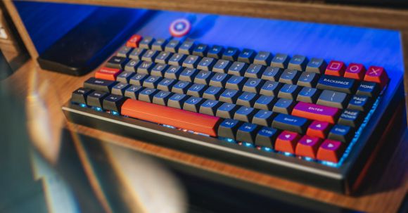 Ergonomic Office Equipment - From above contemporary mechanical keyboard of black and red colors with lightning placed on wooden computer desk