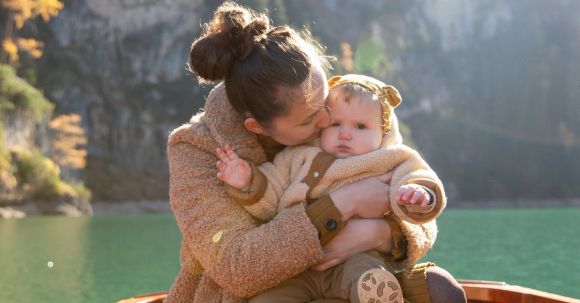 Toddler's Shoes - Woman in Brown Sweater Carrying Baby in Brown Sweater