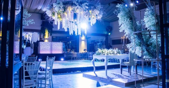 DIY Wedding Decorations - A wedding reception with a large chandelier and white flowers